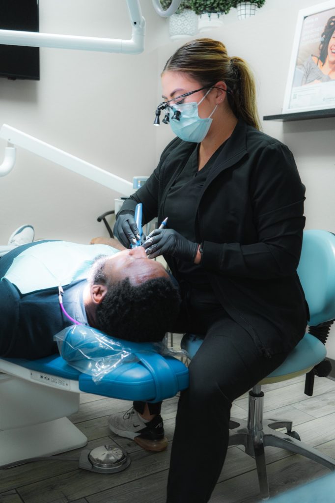 Glisten Dental hygienist performing a teeth cleaning